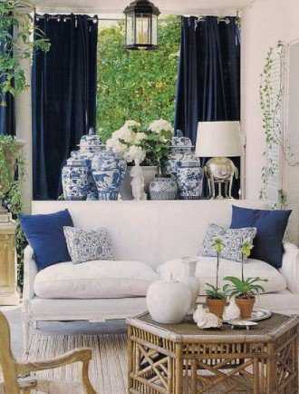 λευκός καναπές με μπλε μαξιλάρια και κουρτίνες